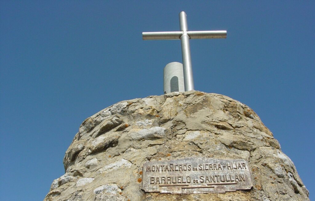 La Placa Metálica:
Se lee claramente la inscripción: "Montañeros de Sierra Hijar - Barruelo de Santullán", un homenaje al grupo de montañeros que lideró la reconstrucción del torreón en 1962.
La placa refuerza la conexión entre la estructura y la comunidad de Barruelo de Santullán.
La Cruz Metálica:
En la cima del torreón se encuentra una cruz de metal de diseño simple y armonioso, que fue instalada como parte de la reconstrucción. Esta cruz es uno de los símbolos distintivos del torreón y puede verse desde la distancia.